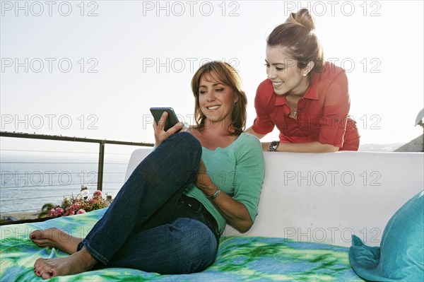 Caucasian women using digital tablet at waterfront