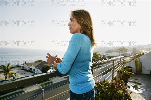 Caucasian woman drinking wine at waterfront