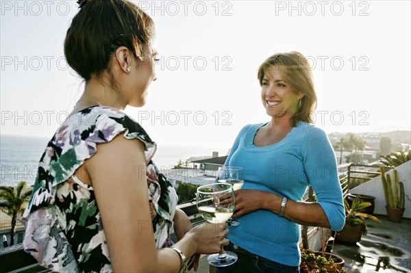 Women drinking wine at waterfront