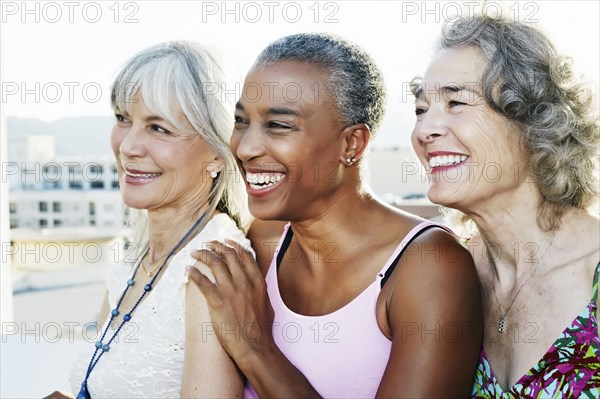 Women smiling together on urban rooftop