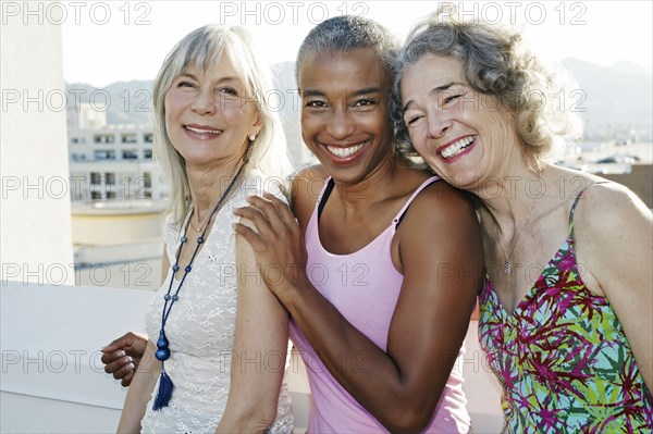 Women smiling together on urban rooftop