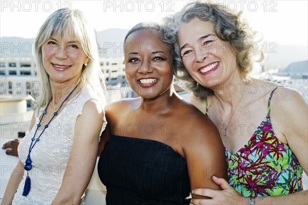 Women smiling together on urban rooftop