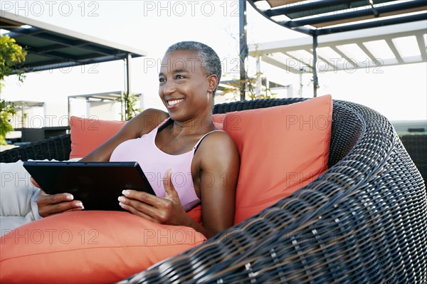 Black woman using digital tablet on urban rooftop