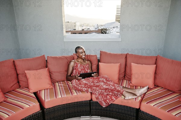 Black woman using digital tablet on urban rooftop