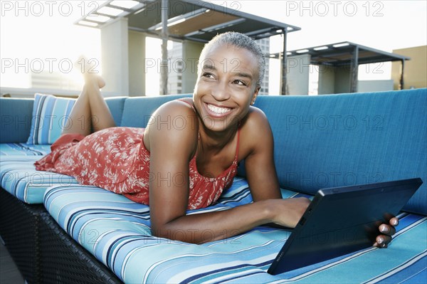 Black woman using digital tablet on urban rooftop