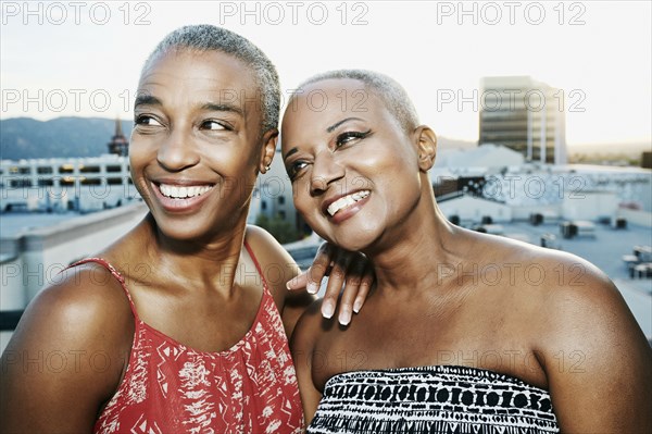 Black women smiling on urban rooftop