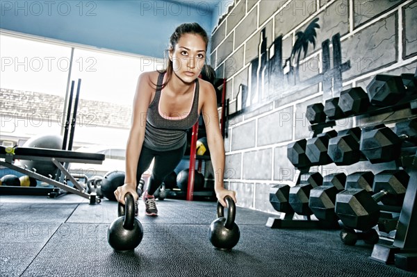 Mixed race woman exercising in gym