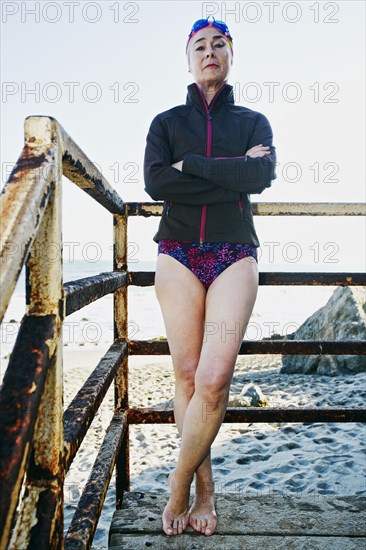 Older Caucasian woman standing on stairs on beach