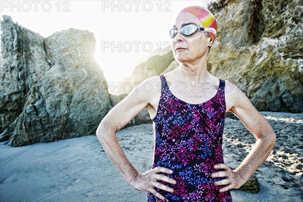 Older Caucasian woman wearing goggles and swimsuit on beach