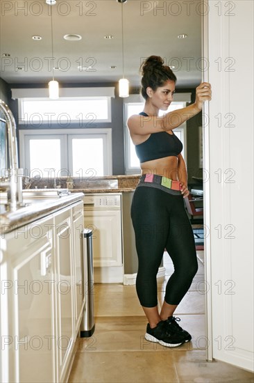 Athletic mixed race woman searching for food in fridge