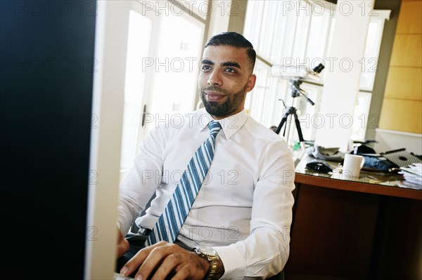 Middle Eastern businessman working at computer in office