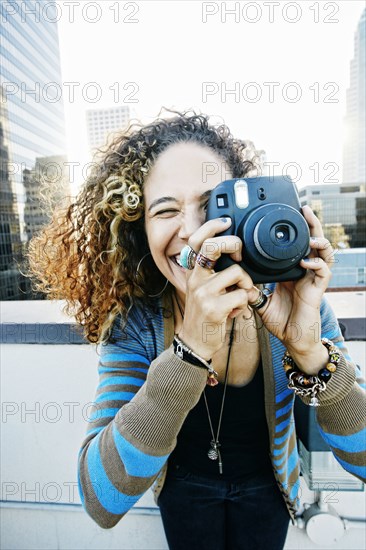 Woman photographing on urban rooftop