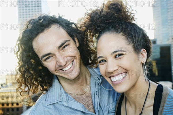 Couple smiling on urban rooftop