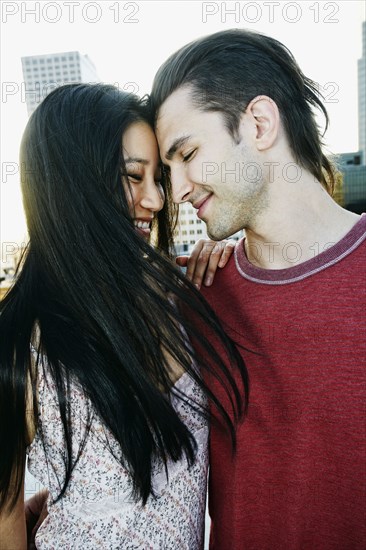 Smiling couple hugging on urban rooftop