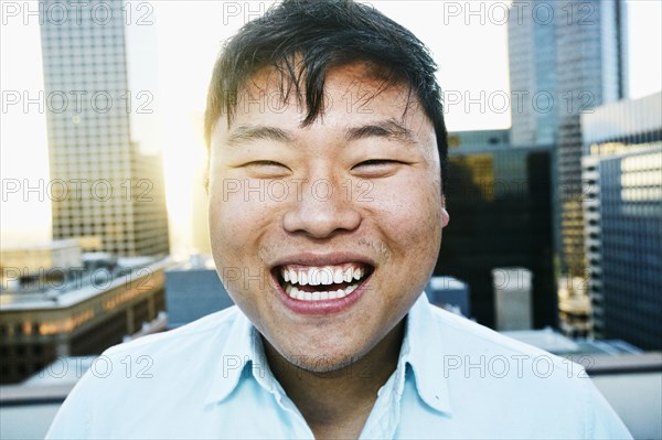 Korean man smiling on urban rooftop