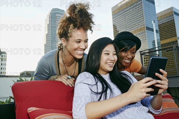 Women using digital tablet on urban rooftop