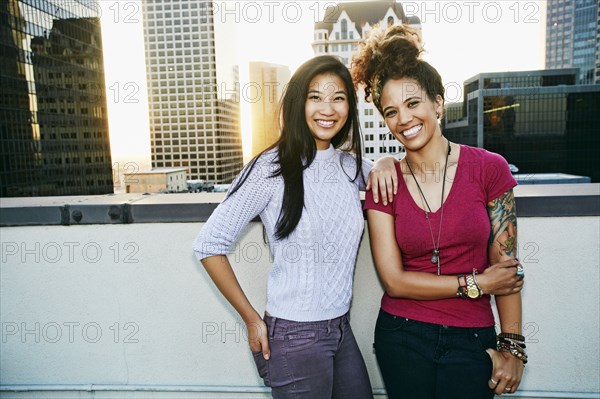 Women smiling on urban rooftop