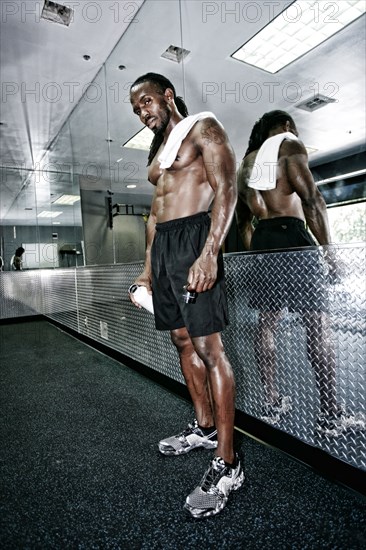 African American man standing at mirror in gym