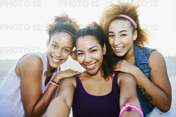 Smiling friends taking selfie at beach