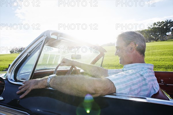 Caucasian man driving classic convertible