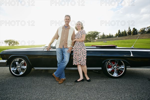 Couple smiling near classic convertible