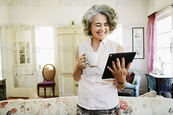 Caucasian woman using digital tablet in living room