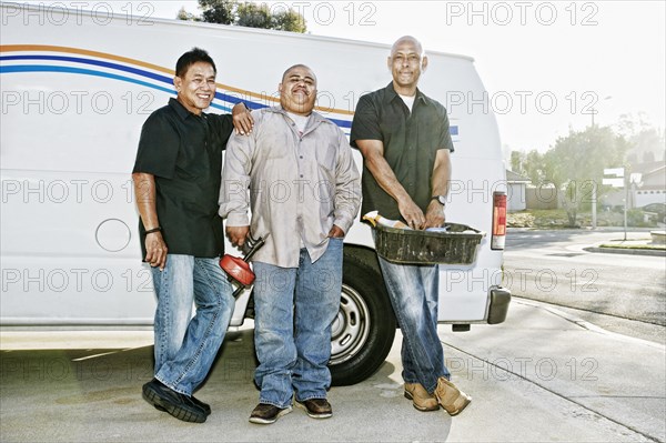 Plumbers smiling near van