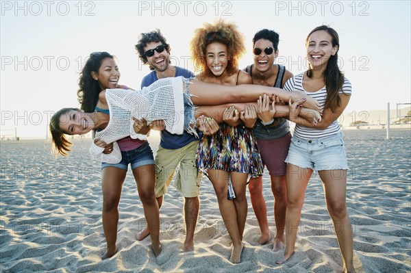 Smiling friends posing together on beach