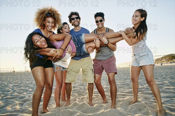Smiling friends posing together on beach
