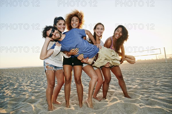 Smiling friends posing together on beach