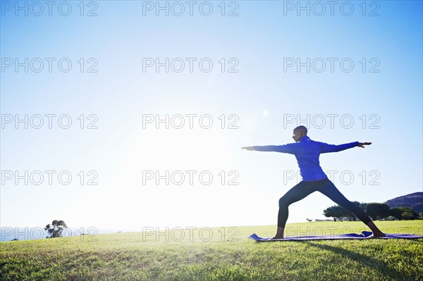 African American woman practicing yoga in park