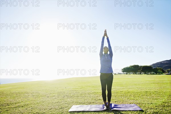 African American woman practicing yoga in park