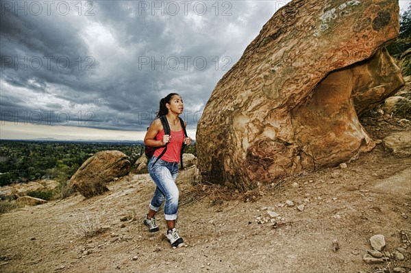 Hispanic woman hiking on rocky hillside