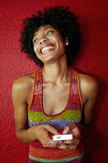 Smiling black woman using cell phone