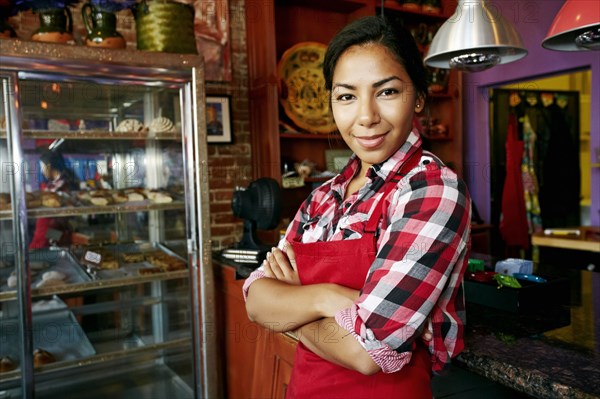 Hispanic waitress smiling in bakery