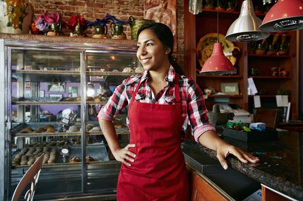 Hispanic waitress smiling in bakery