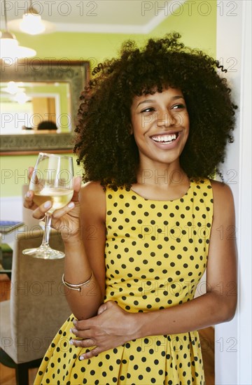Mixed race woman drinking glass of white wine