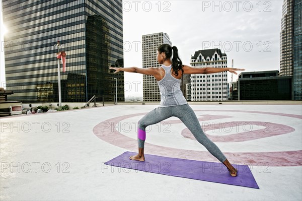 African American woman practicing yoga on urban rooftop