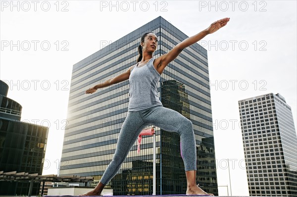 African American woman practicing yoga on urban rooftop