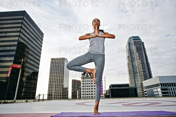 African American woman practicing yoga on urban rooftop