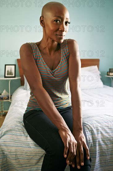 Smiling African American woman sitting on bed