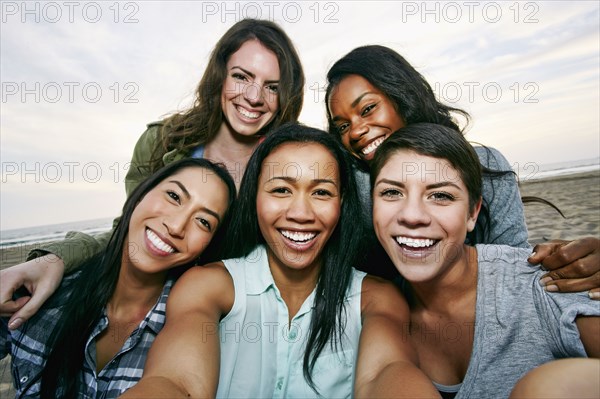 Smiling women taking selfie on beach