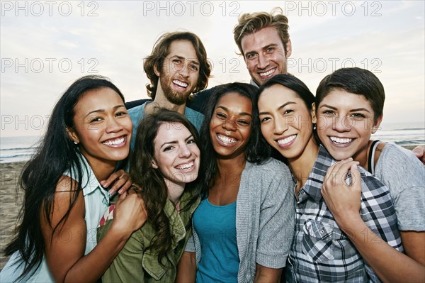 Smiling friends standing on beach