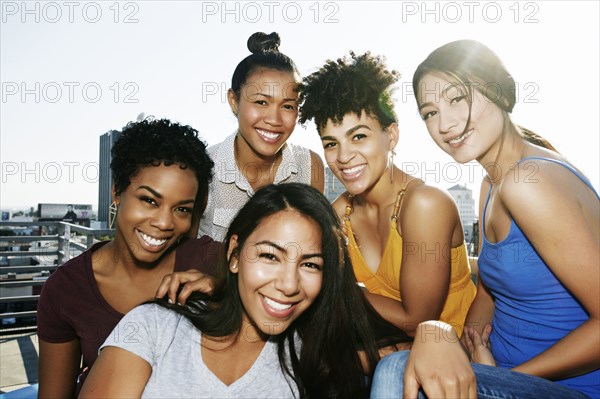 Women smiling on urban rooftop