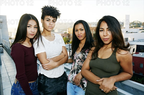 Serious women standing on urban rooftop