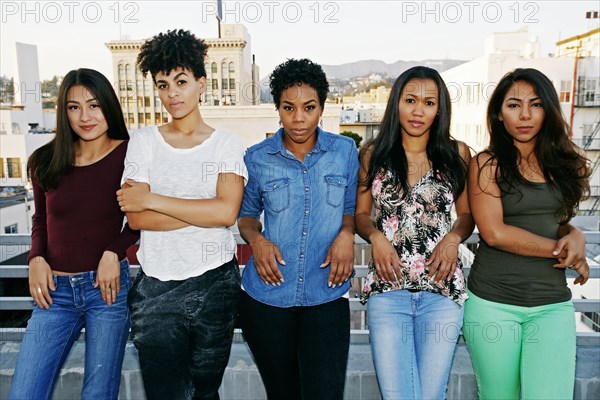 Serious women standing on urban rooftop