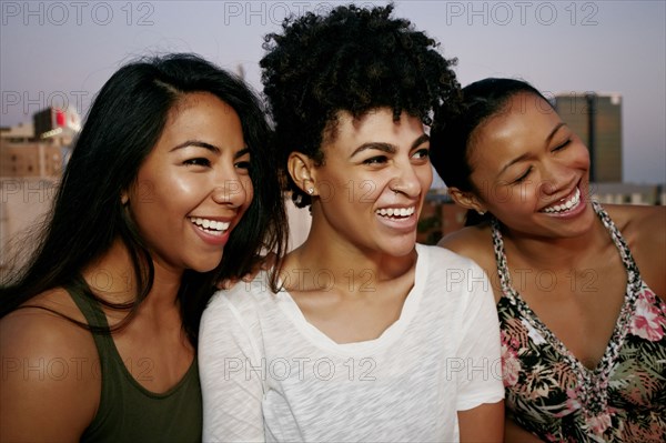 Women smiling on urban rooftop