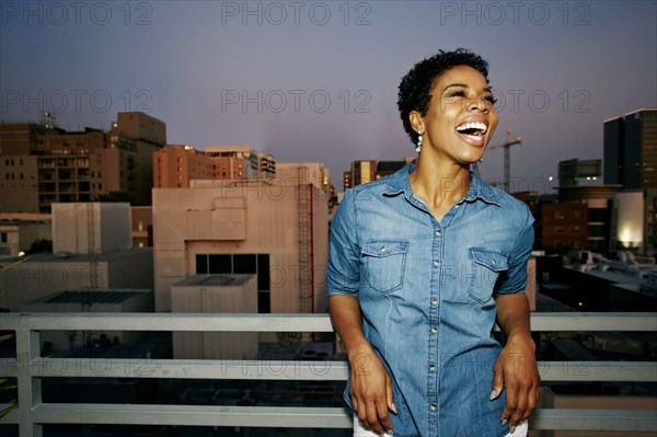 Woman laughing on urban rooftop