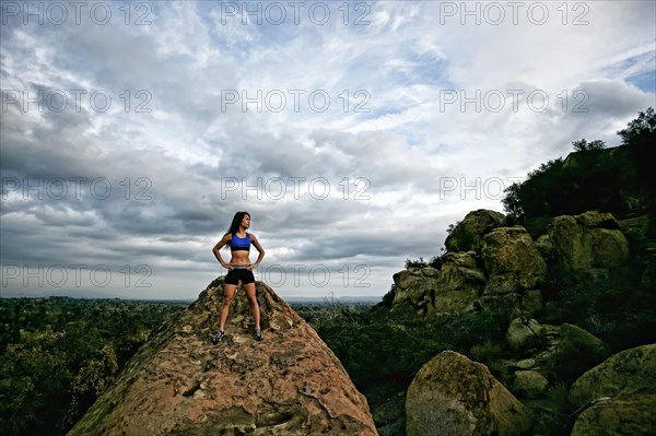 Vietnamese woman standing on rocky hilltop