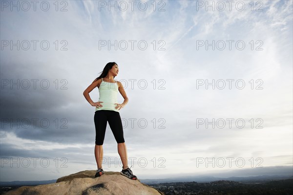 Vietnamese woman standing on rocky hilltop